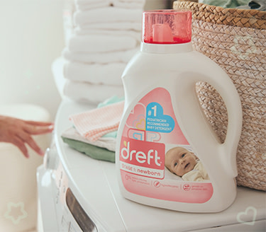 Dreft liquid detergent for getting food stains out of baby clothes on top of a washing machine
