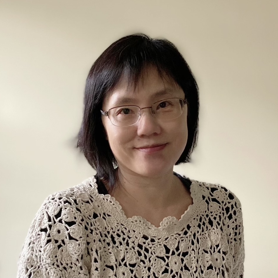 headshot of a smiling woman with dark hair and glasses}}