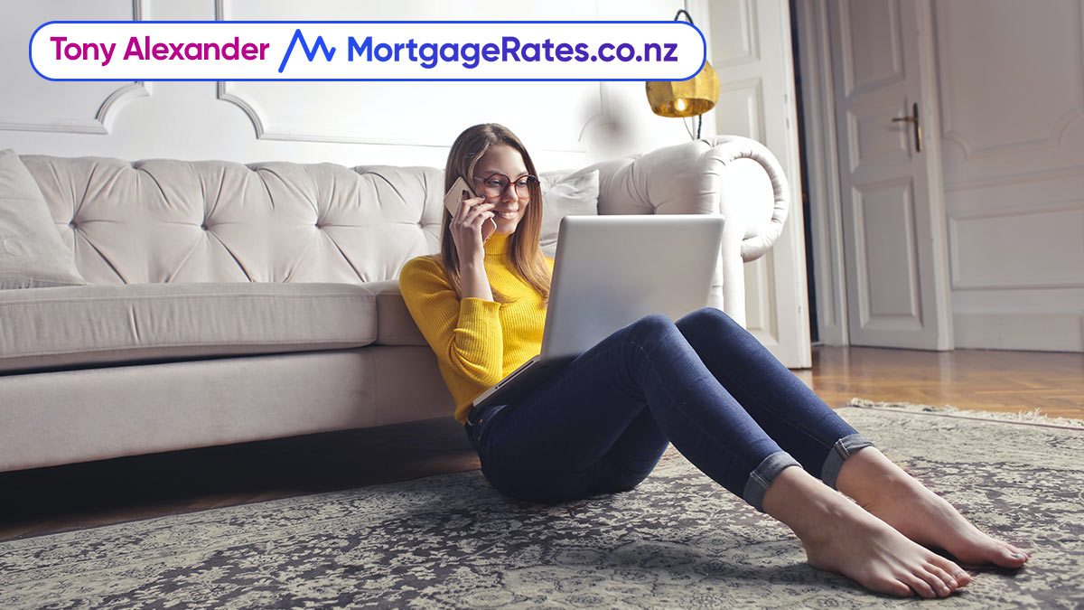 Young woman sitting on floor with laptop and phone
