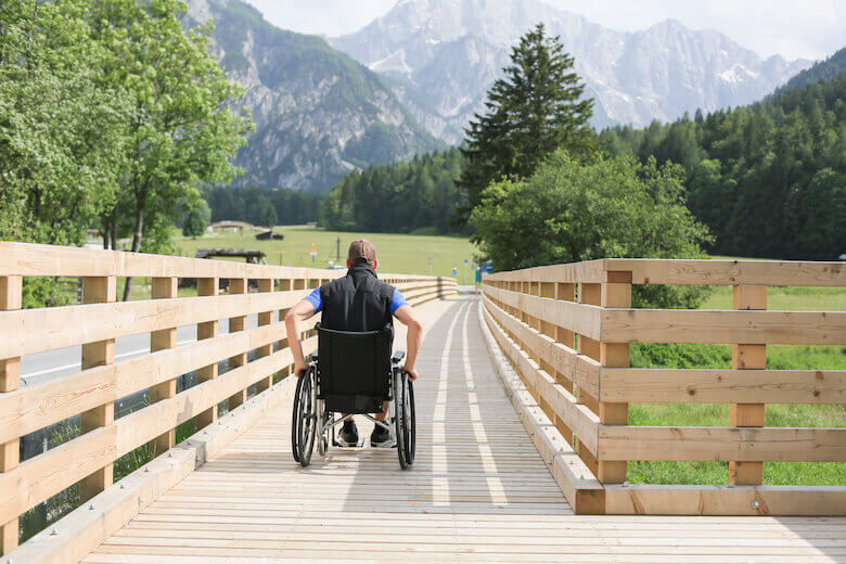 Une personne en fauteuil roulant utilise des chemins sans obstacles lors d'une sortie dans la nature.