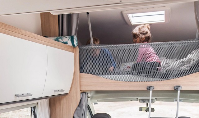 Two children playing in the alcove of a camper van