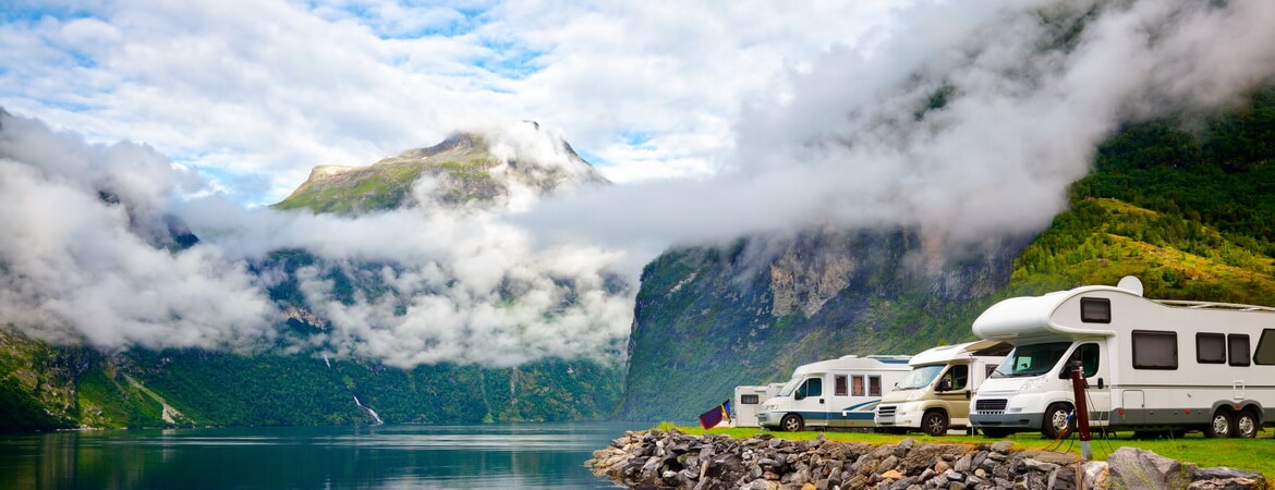 Motorhomes parked in the middle of a picturesque mountain landscape. 