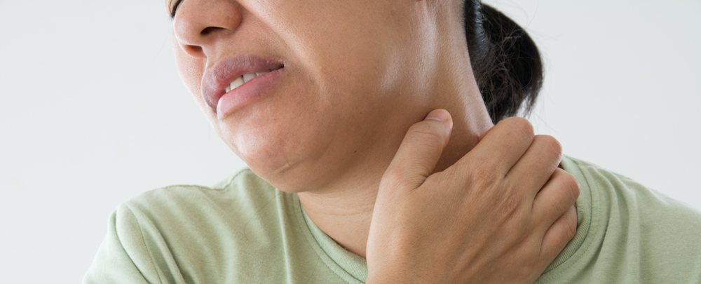 woman with skin of color scratching neck