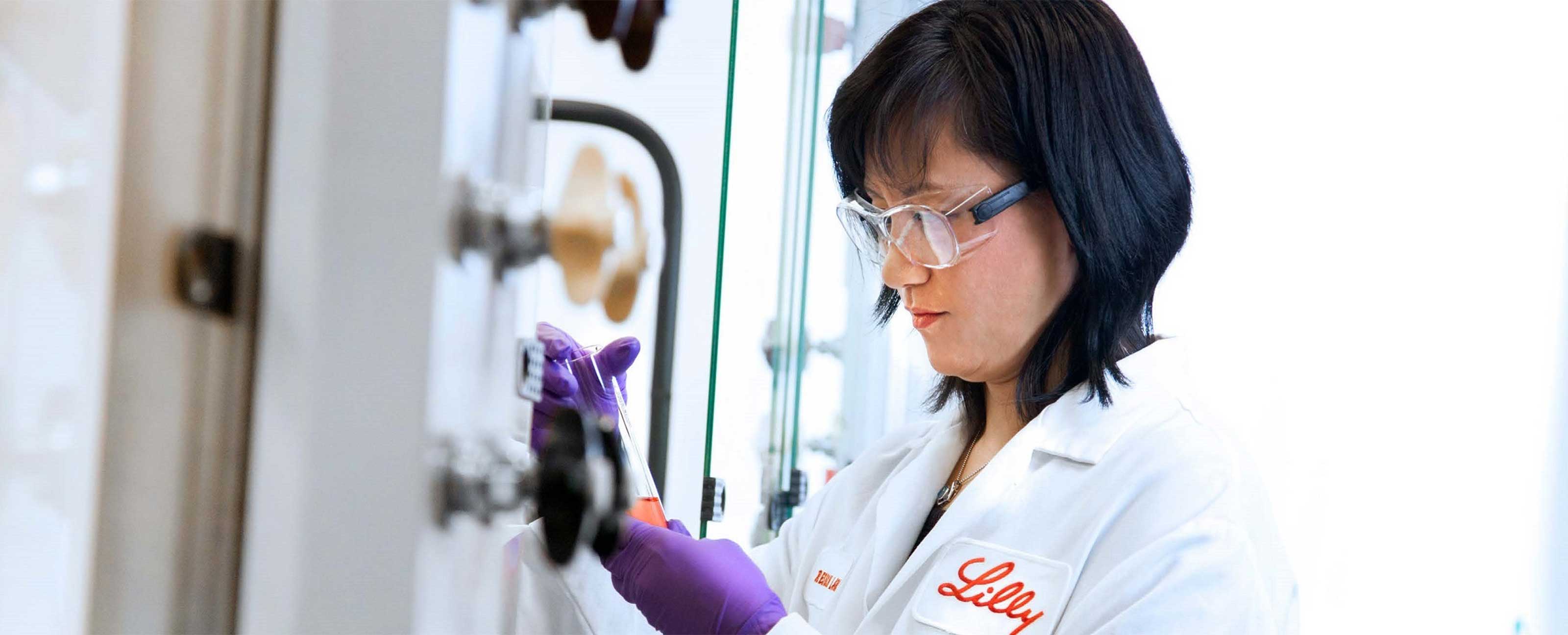 scientist looking down at vial