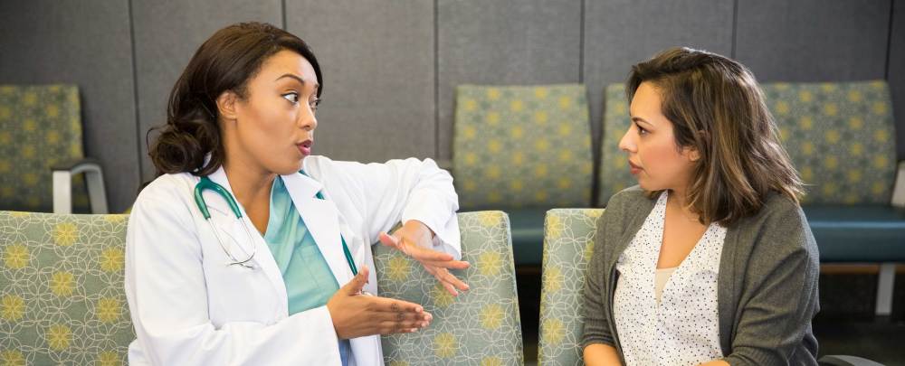 doctor talking to woman in waiting room