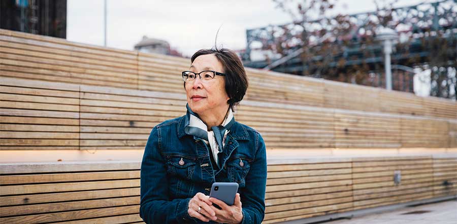 woman sitting outside holding smartphone