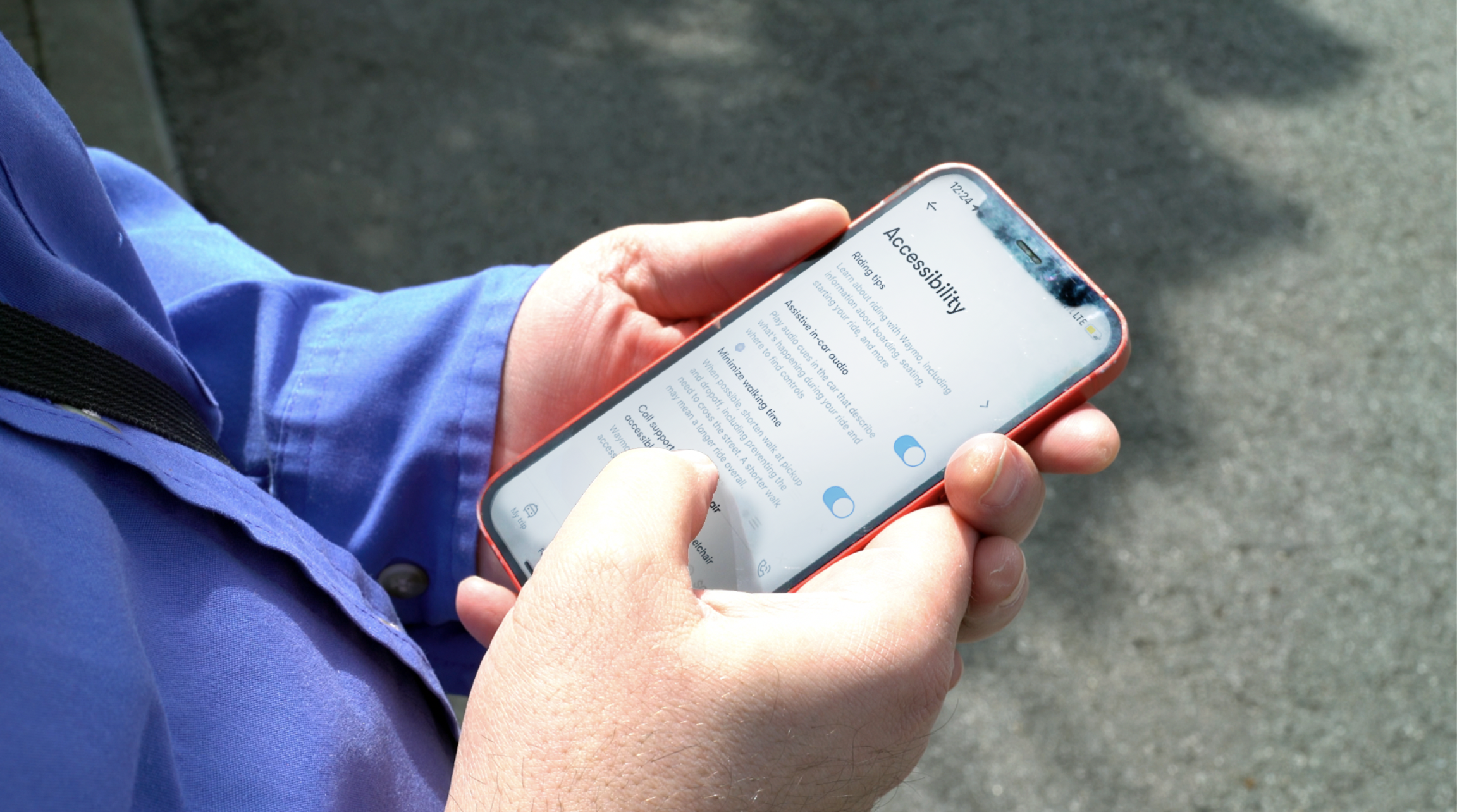 Aerial photo of hands holding a phone with the screen on a settings page titled "Accessibility"