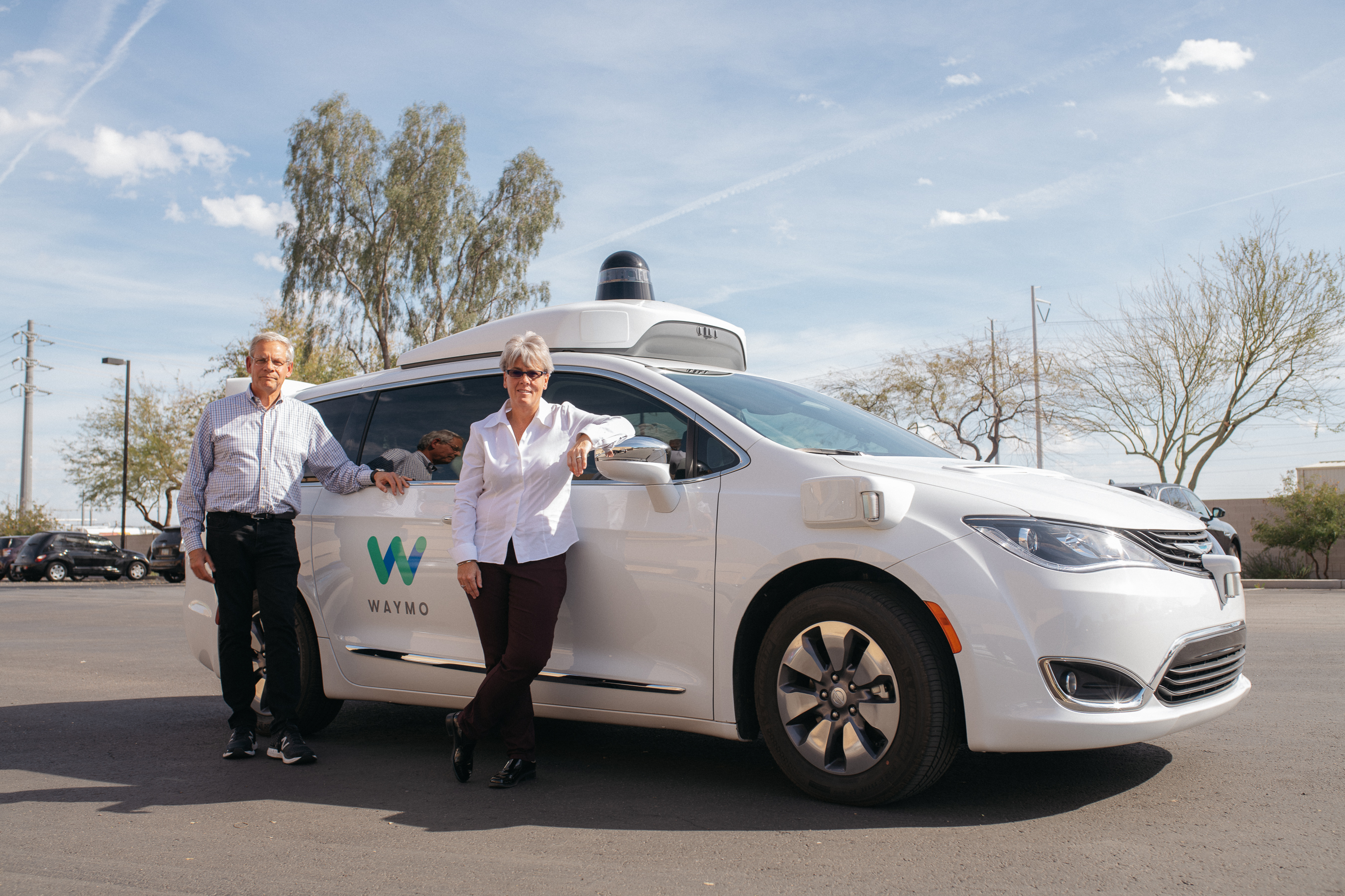 Alex and Kelly of the National Safety Council beside a Waymo vehicle