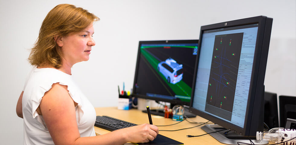 Woman working at computers on autonomous driving