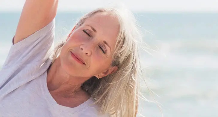 Ältere Frau macht Yoga in der Sonne