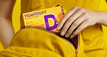 Eine Frau hält eine Vigantolvit Tablette