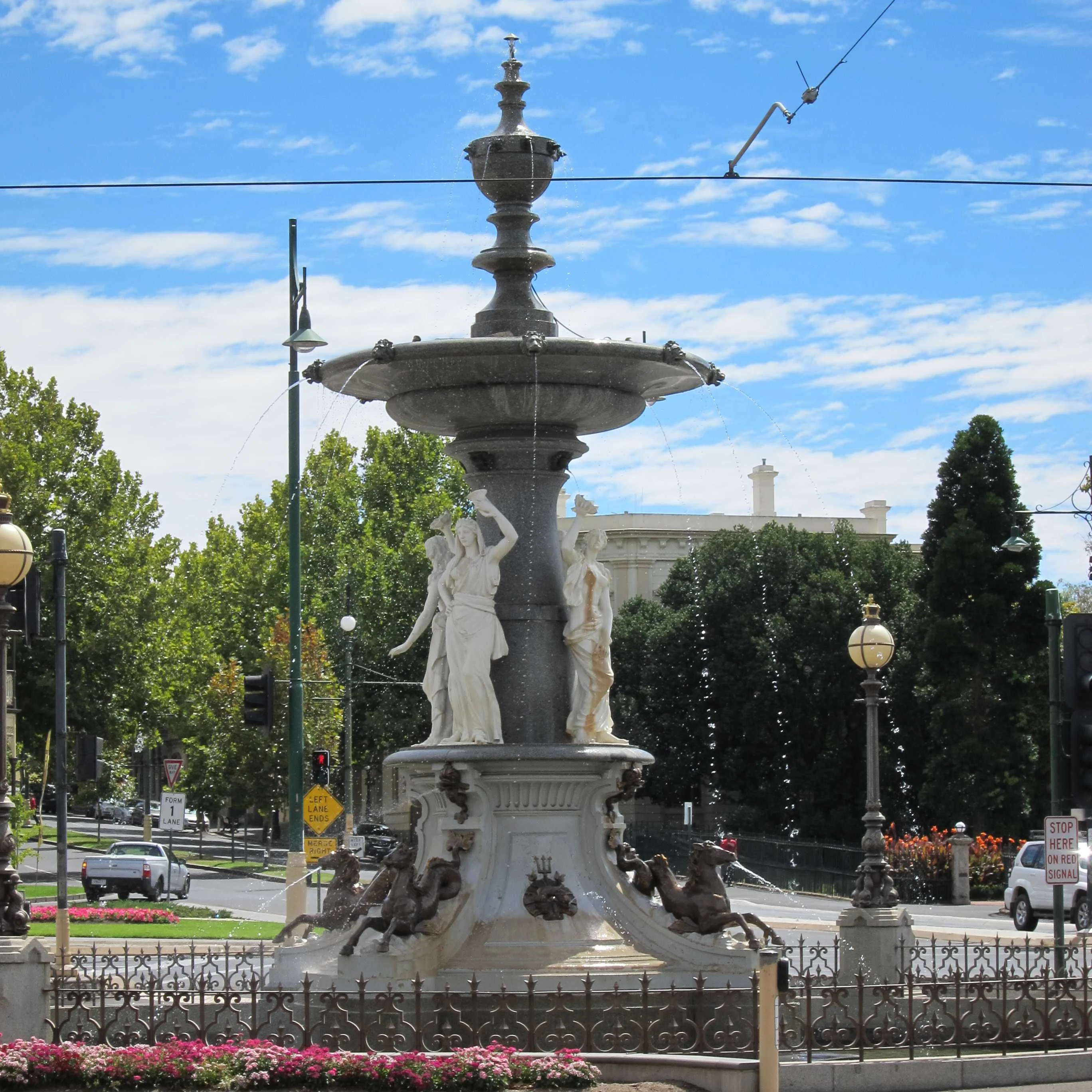 Tall fountain with white statues on the base