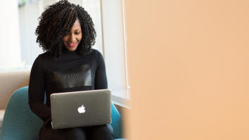 Female student on laptop smiling