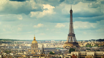 View of Paris with the Eiffel Tower and many other buildings under a cloudy blue sky