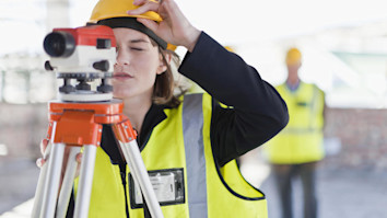 Construction student using equipment to survey