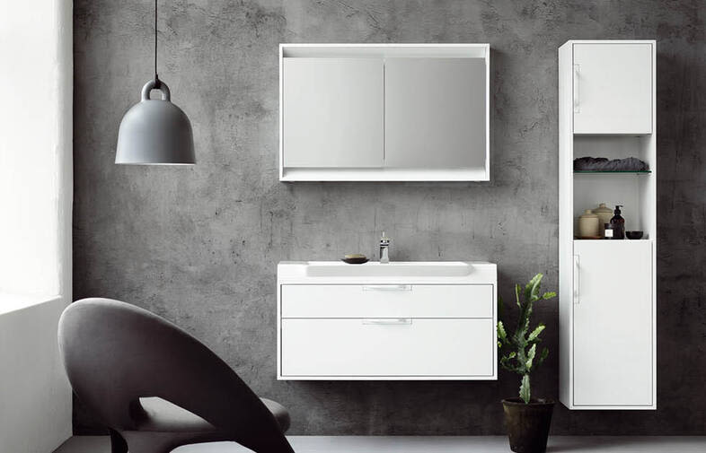 Minimalistiskt badrum med grå betongvägg, vit kommod, spegelskåp, hänglampa, fåtölj och växt