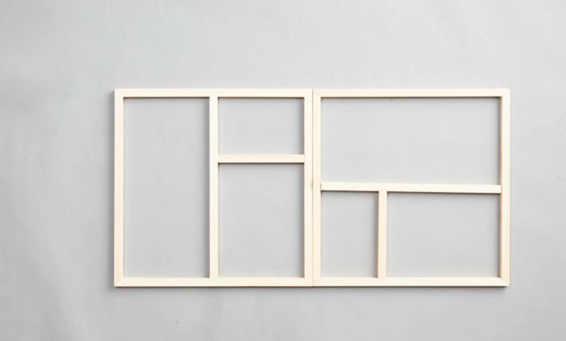 Omålad träram med sex fält i olika storlekar på ljusgrå vägg