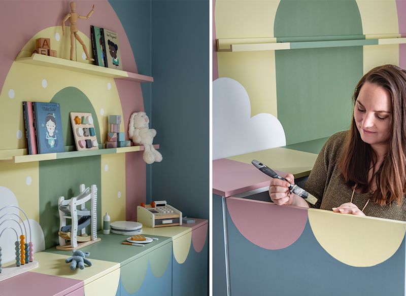 Pastellig lekhylla med böcker, träleksaker och mjukisdjur, en person målar ytan