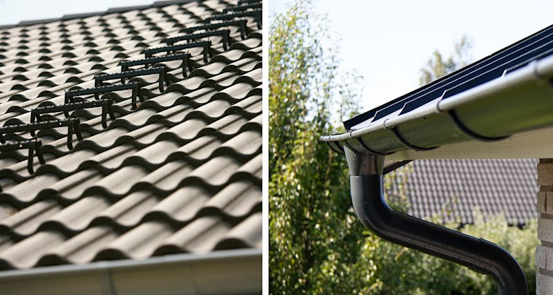 Grått vågformat tegeltak med svarta snöfångare, svart hängränna vid husgavel mot gröna träd.