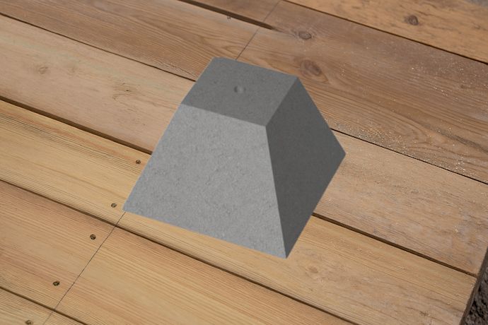Betongplint placerad på ett trädäck, används som stabil grund för altan- och byggkonstruktioner.