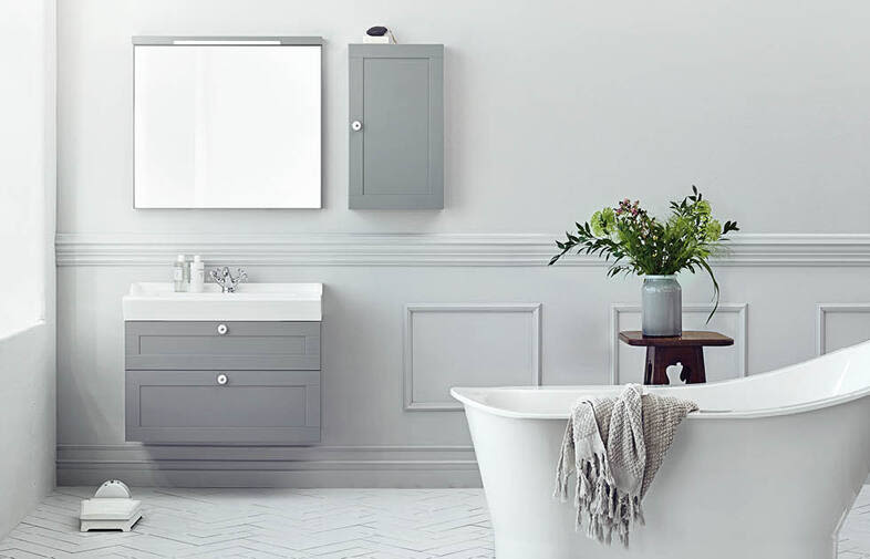 Minimalistiskt grått och vitt badrum med fristående badkar, handduk, vask och vas med gröna växter.