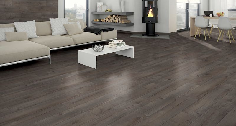 Mörkt trägolv i vardagsrum med inredning och öppen spis