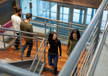 4 people walking down a staircase talking to each other