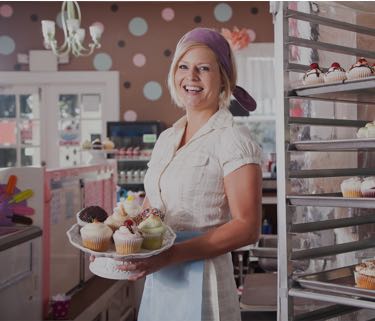 baker holding cupcakes