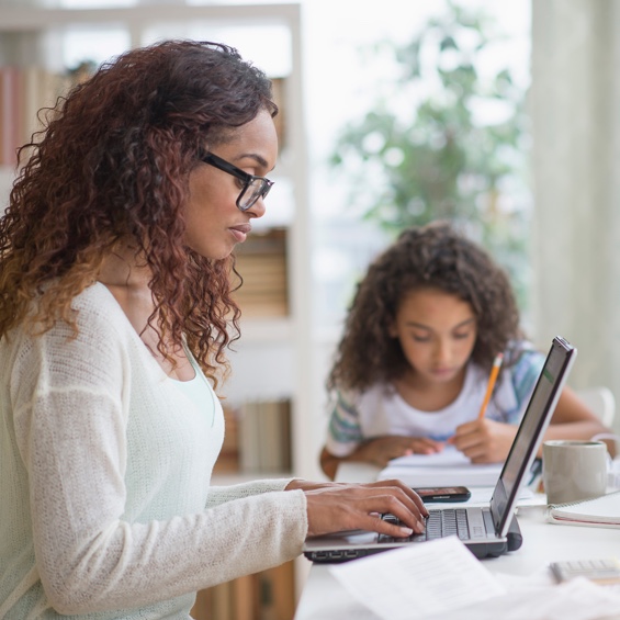Mother working alongside her daughter at a table