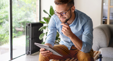 man sitting down looking at a tablet device