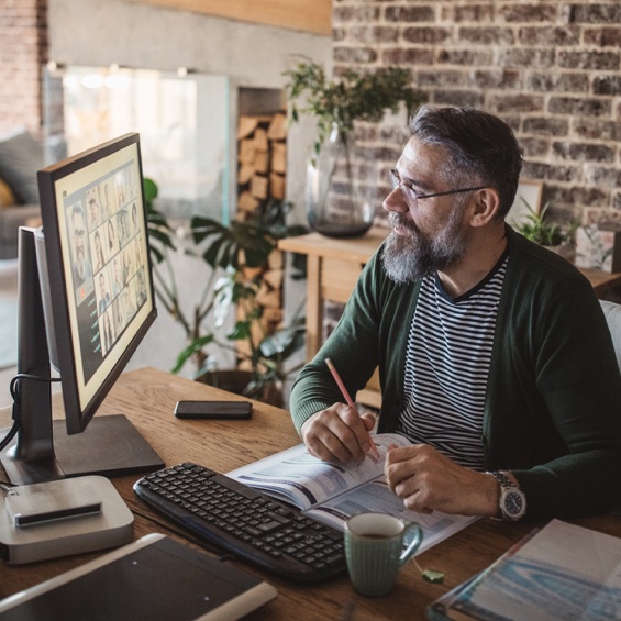 Man holding a pencil while working at his office desk