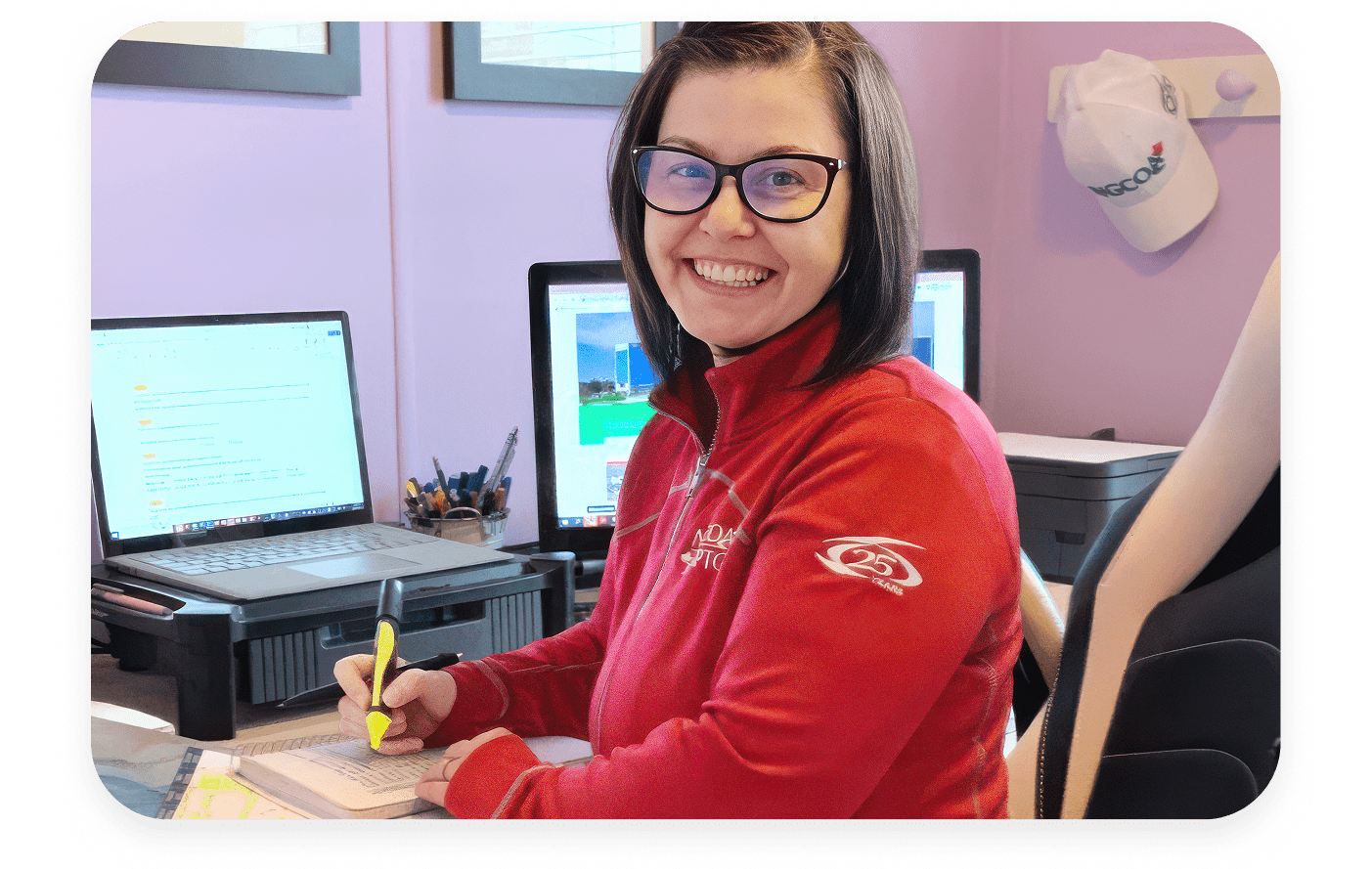 A woman sitting at a desk smiling at the camera