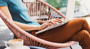 Person sitting in chair typing on a laptop