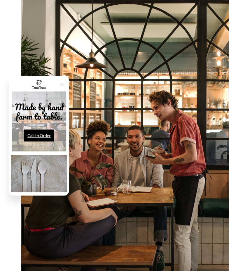 Image of friends eating dinner at a restaurant while the waiter takes their order