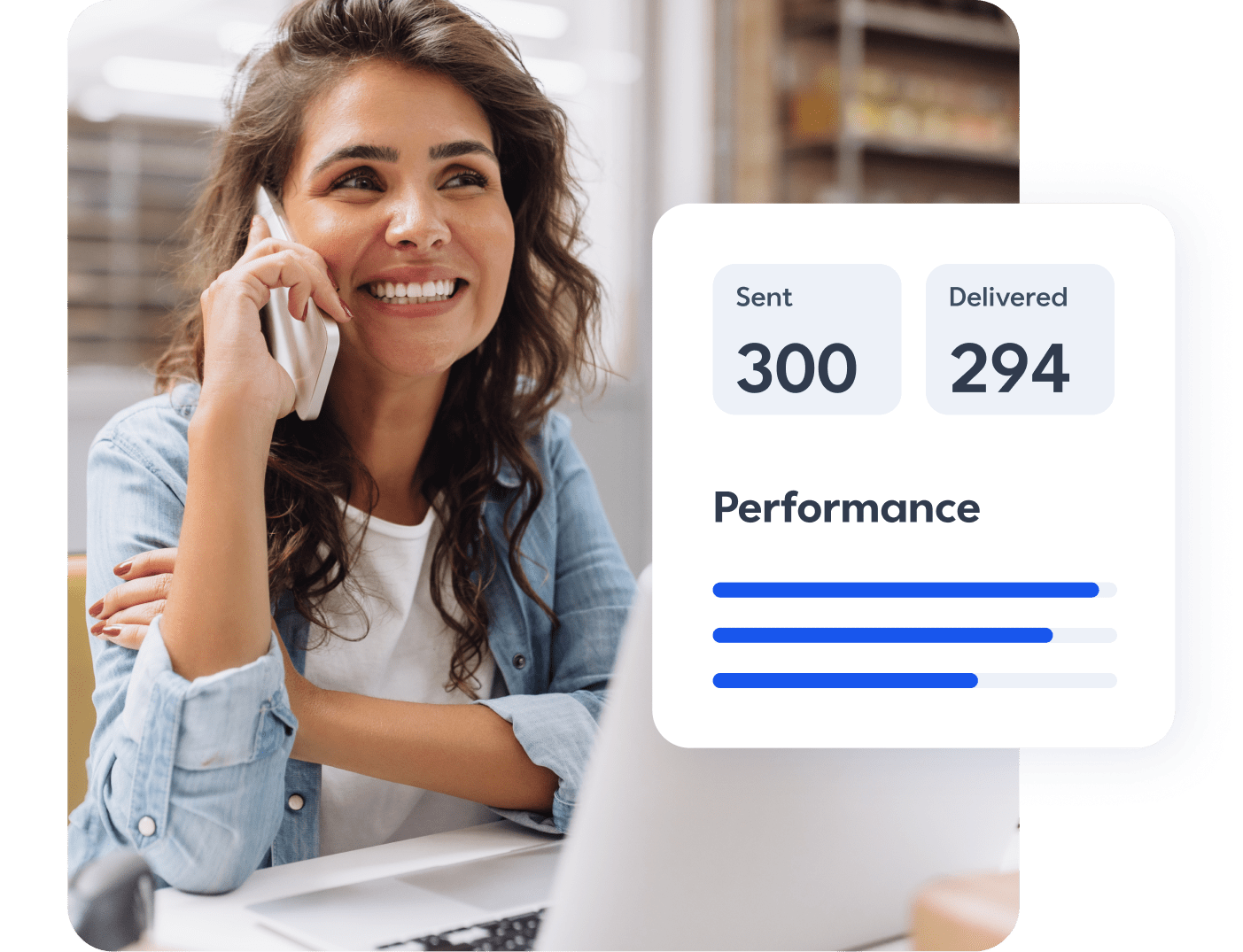 Business woman on the phone and smiling at her laptop with a view of her digital marketing performance within Constant Contact