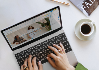 Person typing on laptop while building their website