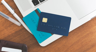 credit cards laying on top of a laptop
