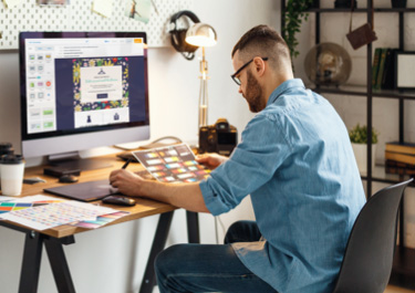 man sitting at a desk working on his computer