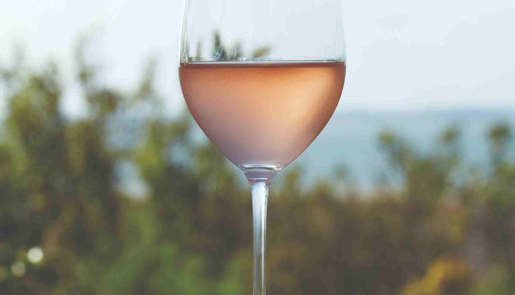 Glass of rosé outdoors with sea in background