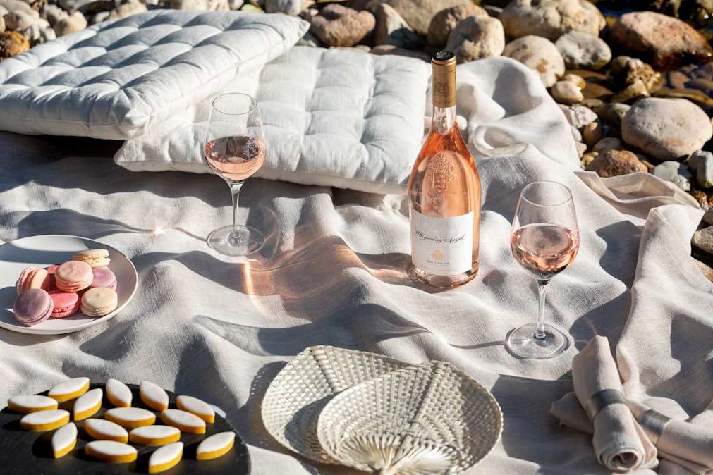 A picnic image with a bottle of Whispering Angel and two glasses