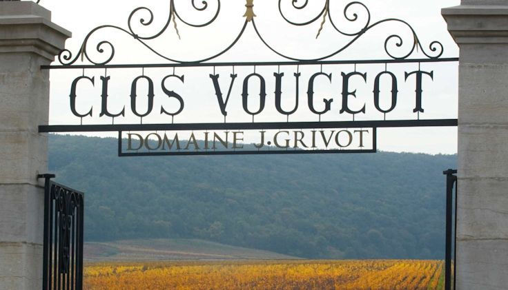 Stone gateway to the walled vineyard of Clos Vougeot with wrought iron sign