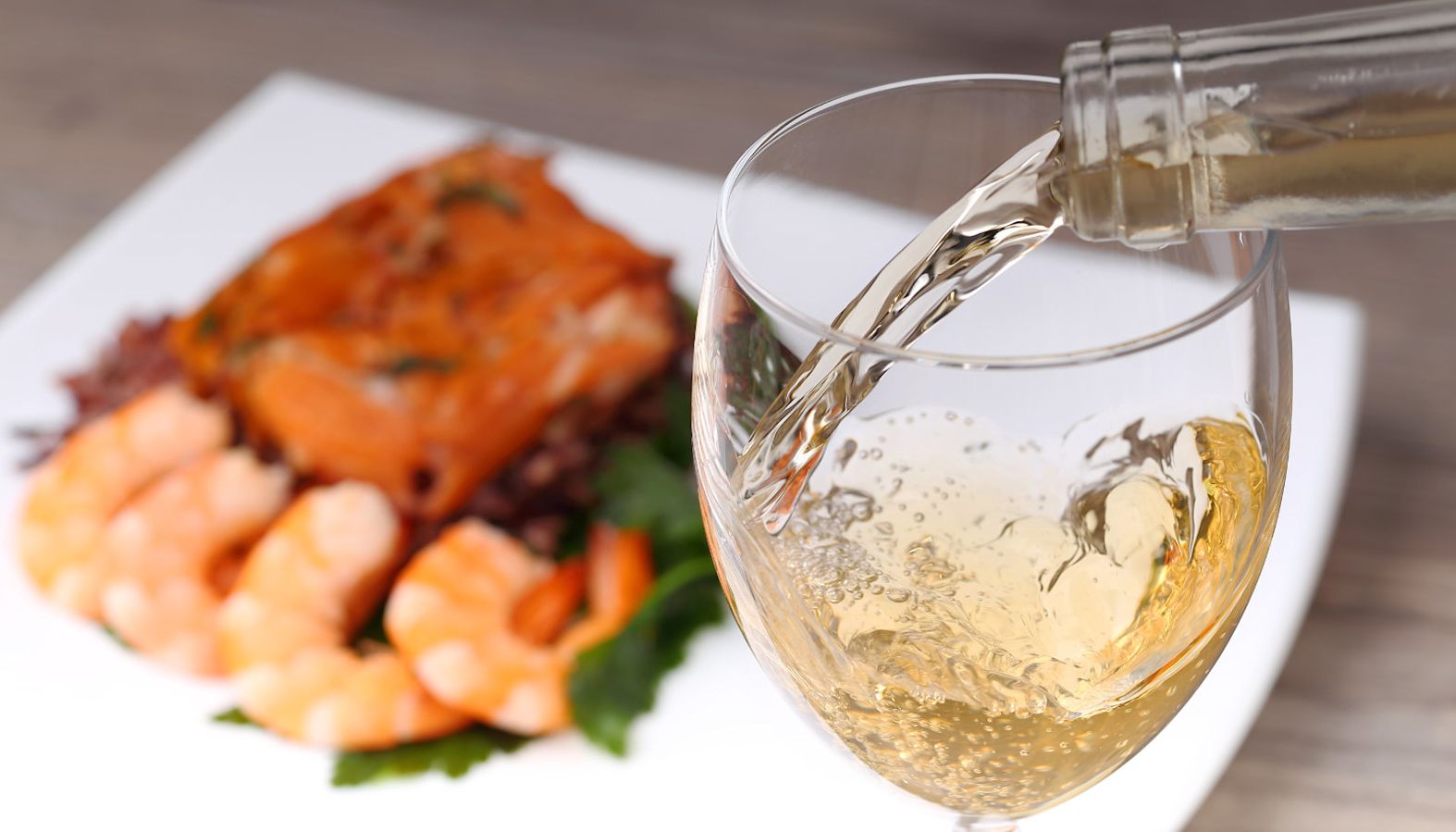 Salmon dish with prawns and a glass of white wine - wine with salmon