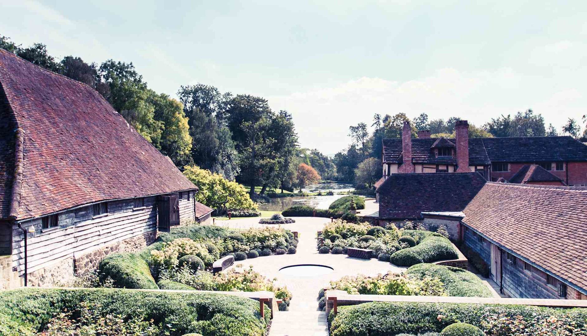 Old English buildings around ornate gardens