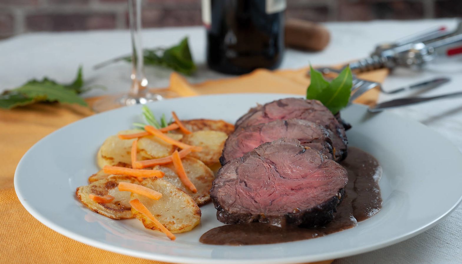 Red meat with potatoes and gravy on a white plate - Barolo