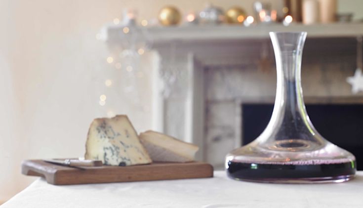 A cheeseboard with stilton and a decanter of red wine