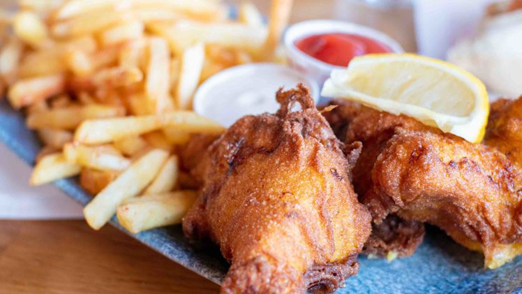 Fish and chips with ketchup and a slice of lemon