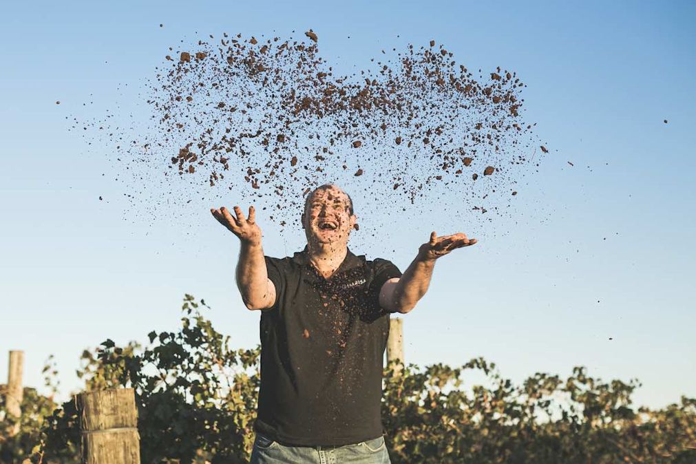 An image of winemaker Johnny Q throwing soil into the air in New South Wales
