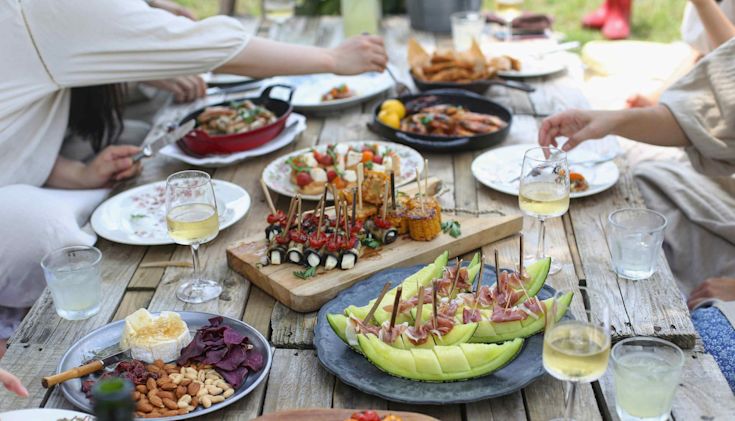 White wine glasses on table outdoors with food