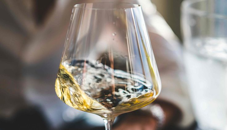 Rich golden white wine swirling in glass