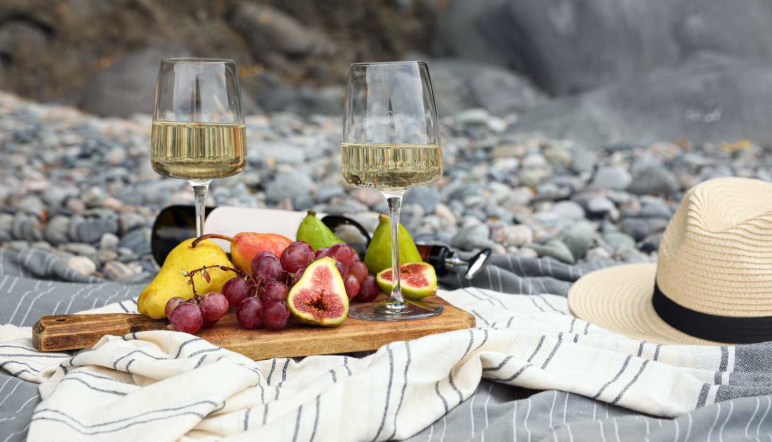 Glasses of white wine on a fruit board at a picnic on the beach - types of white wine